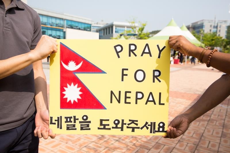 Members of the UNIST International Student Organization (UISO), holding a sign that said "Pray for Nepal" on Saturday near the Student Union Building to raise funds to support the victims and send aid to Nepal.