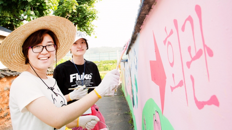 왼쪽부터 김영주 UNIST 기초과정부 1학년 학생과 김상은 기초과정부 1학년 학생이 자신들이 그린 벽화 앞에서 활짝 웃고 있다. 올해 신입생인 두 사람은 벽화 봉사를 하며 더욱 친해졌다.