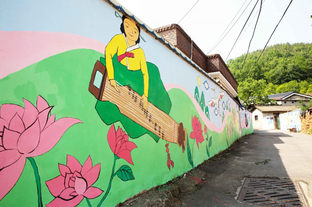 올해 새로 그려진 벽화의 모습이다. 꽃과 풀을 배경으로 가야금을 연주하는 여성을 표현했다. '민속'을 주제로 기획한 그림이다.