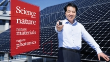 석상일 교수가 UNIST 공학관 옥상에 설치된 실리콘 태양전지 판을 배경으로 서 있다. 그의 손에는 차세대 태양전지의 강력한 후보인 페로브스카이트 태양전지 셀이 들려있다. | 사진: 김경채, 디자인: 박혜지
