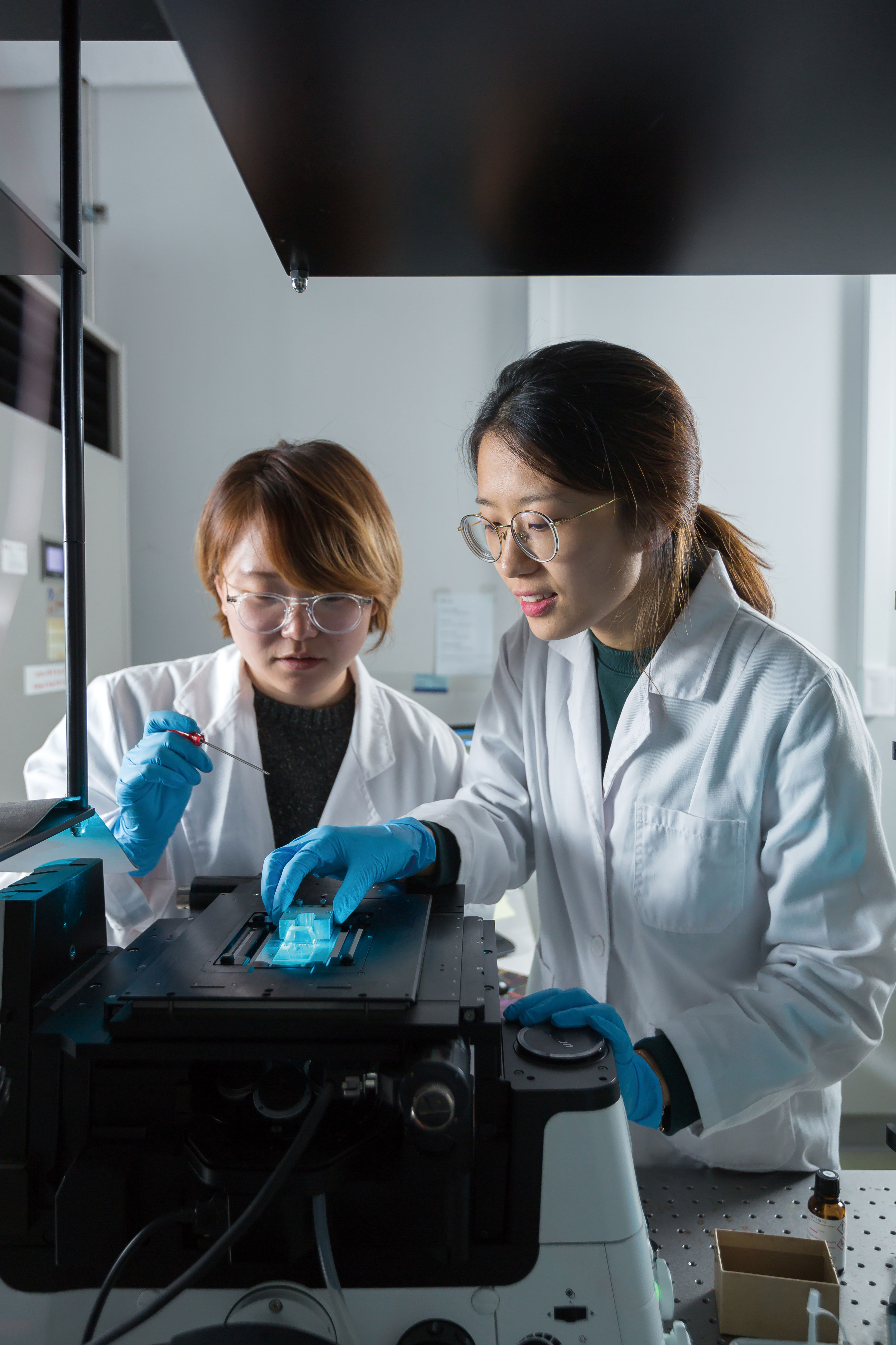 강유진, 천나영 연구원이 DNA 커튼 실험을 위해서 시료 위에 프리즘을 장착하고 레이저를 조사하고 있다. | 사진: 안홍범