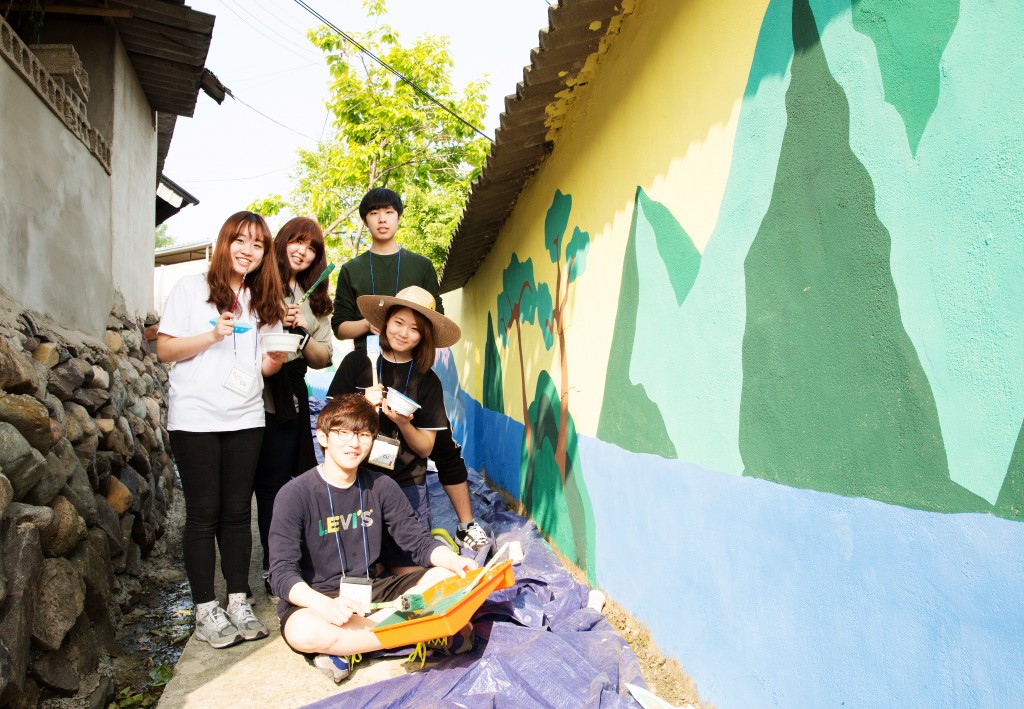 UNIST Club Union Promotion and Support Team is posing for a group photo at the mural painting project on May 15, 2015. The pictire on the far left is SoonJi Lee (School of Life Sciences).