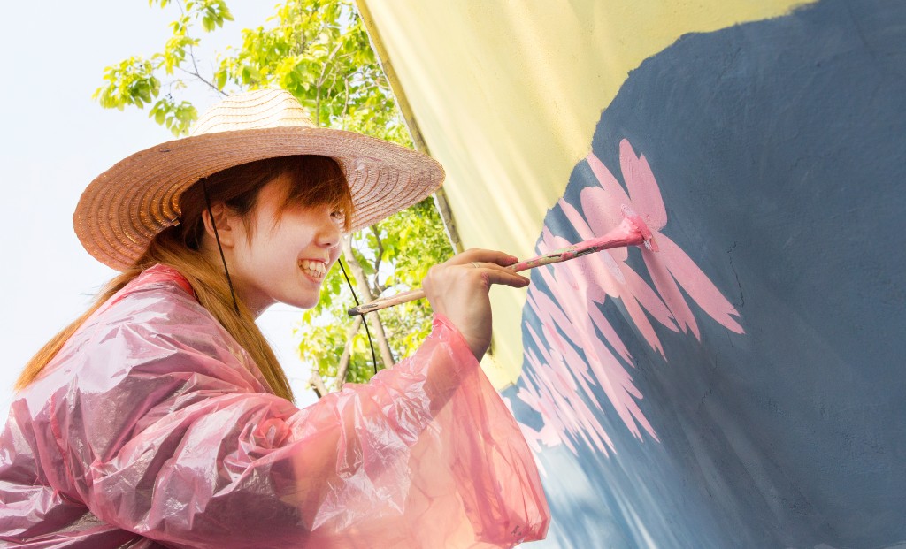 Do Yon Kim (School of Materials Science and Engineering) is painting Japanese apricot flowers on a whale mural.