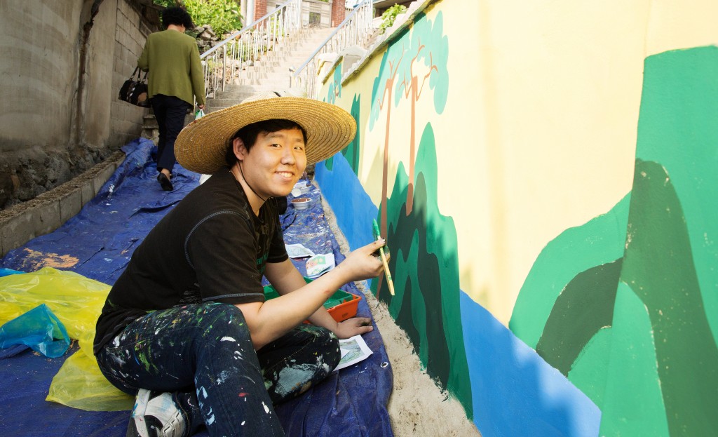 Seung Jin Park (School of Mechanical and Nuclear Engineering) is posing for a portait, while painting a tree mural at the mural painting project, held on May 15, 2015. 