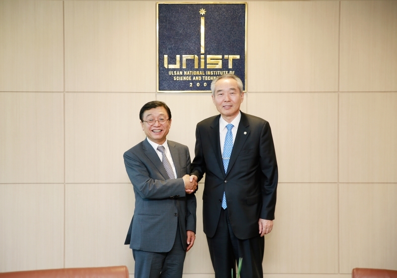 UNIST President Moo Je Cho (right) shake hands with President Yeon-Chun Oh (Left) of Ulsan University.