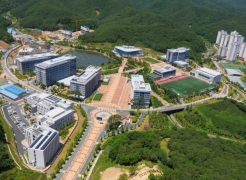 September 28th, 2015 marks the official relaunch of UNIST, as a government-funded research institute. Shown is an aerial view of the UNIST campus as of June 2015. On the left side of the Gamak pond are Engineering Building, Hans Scholer Stem Cell Research Center, and CMCM center. UNIST library and Business Administration Building are located on the right side of the pond. Dormitories are located in the upper right-hand side of the photo.