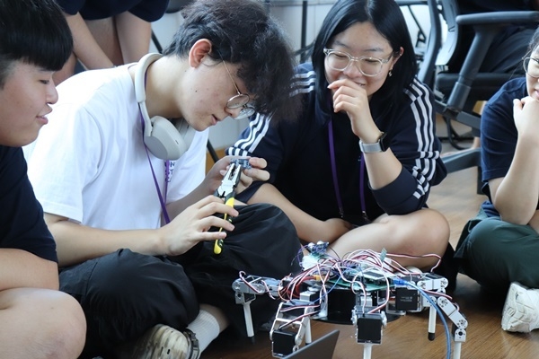 A group of students actively engaged in the construction of a drone.