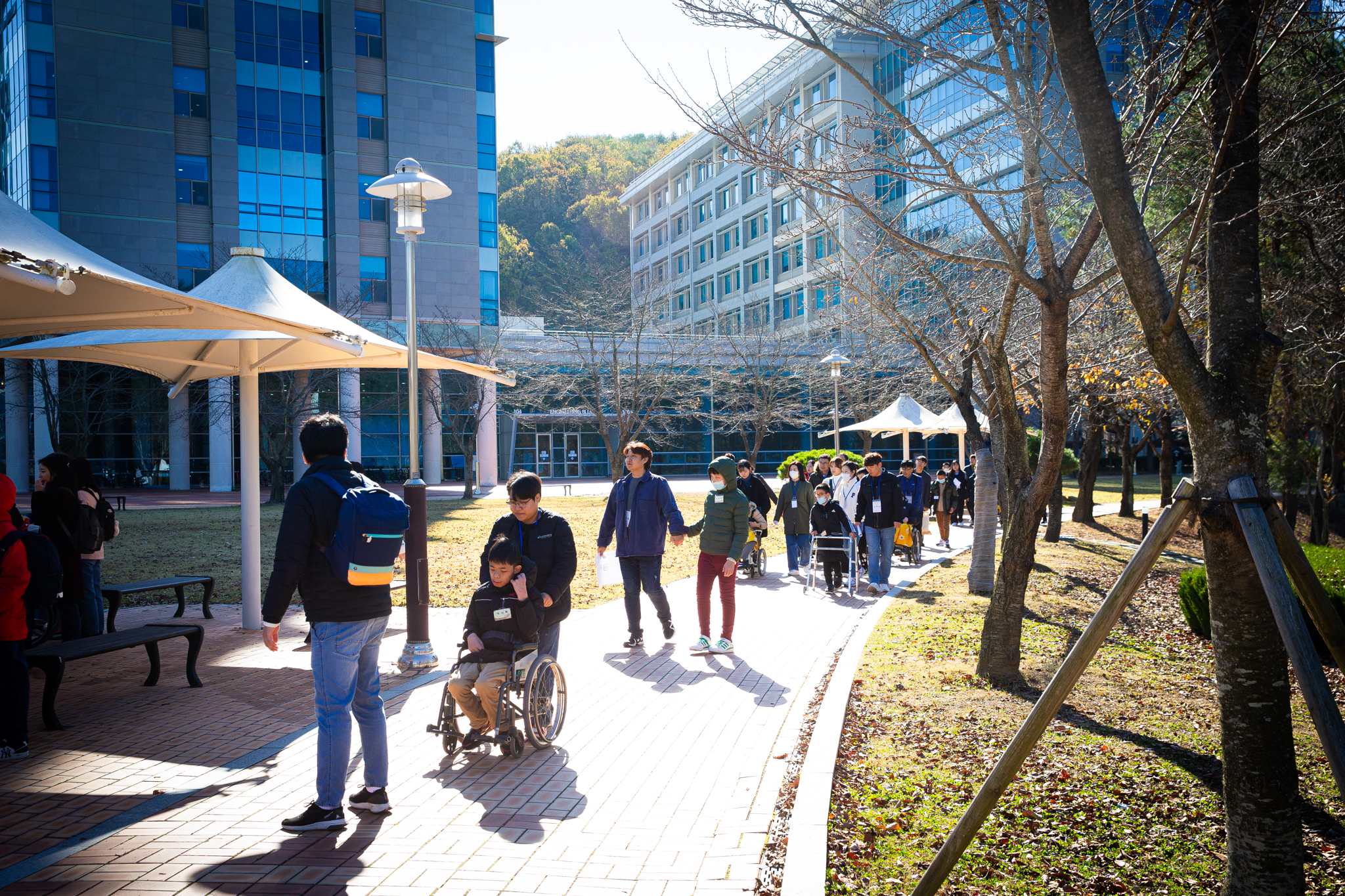 HyeJinWon students are seen leisurely strolling around the Gamak pond, accompanied by volunteers.